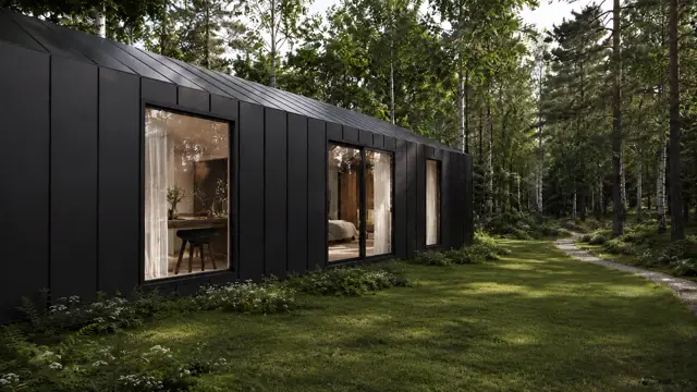 Don Modular Home in a woodland setting — lit interiors seen through the glazing
